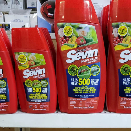 Red bottles of GardenTech Sevin Insect Killer Concentrate displayed on a shelf. Labels feature garden images and text highlighting pest control.