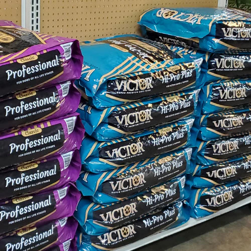 Bags of dog food stacked in a store. Left, purple 